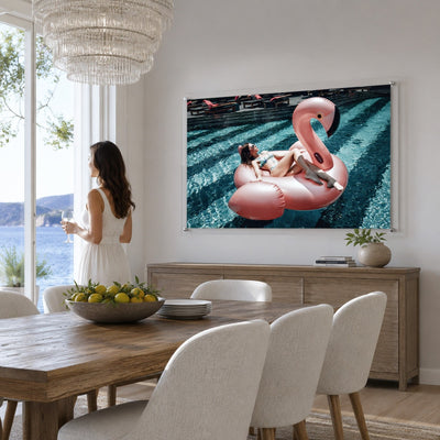Pink flamingo pool wall art in a bright modern dining room with woman standing