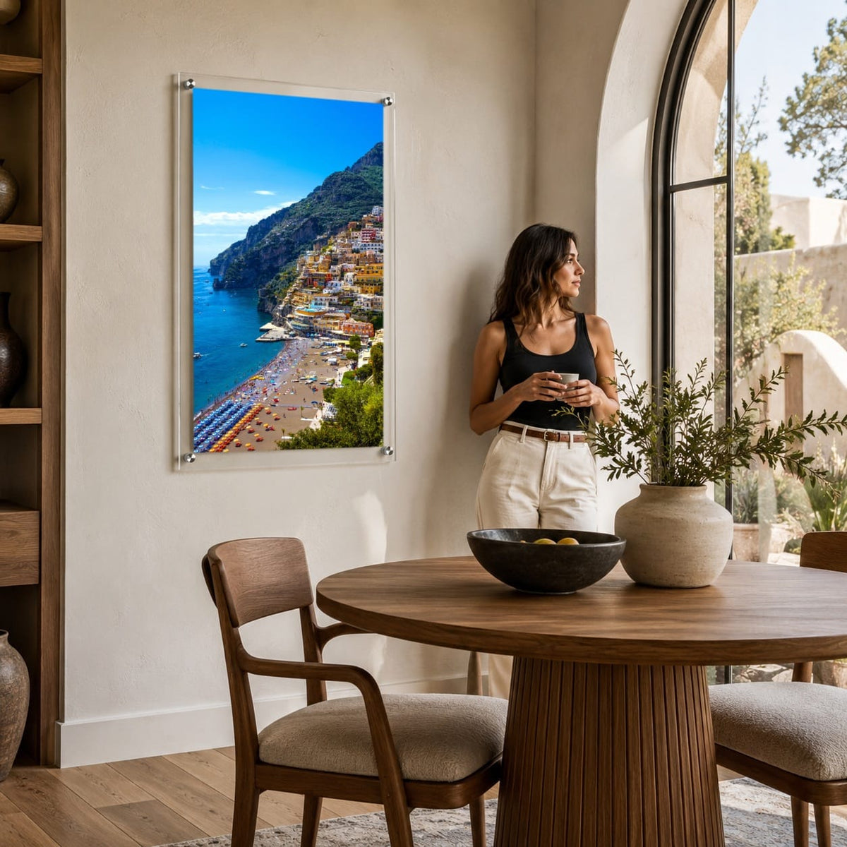 Positively Positano wall art in a bright modern dining room area with woman holding a coffee