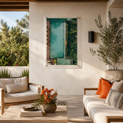 Palm and Circumstance wall art displayed center on a Mediterranean patio sofa