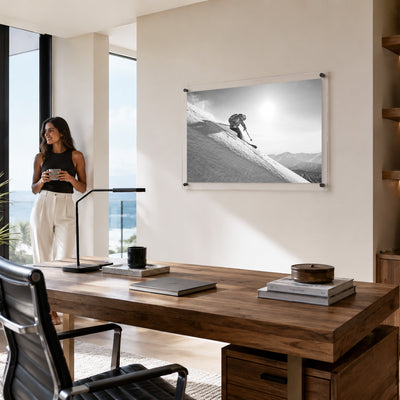 Steep Thrills acrylic wall art displayed above a modern office room table with woman aside