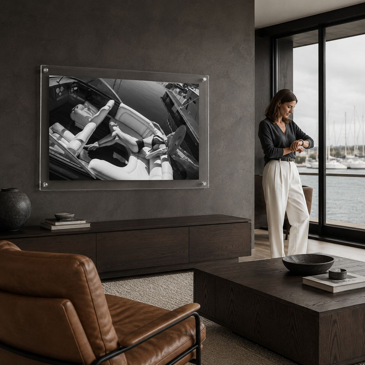 Sea La Vie BW acrylic wall art in a dark living room next to one woman