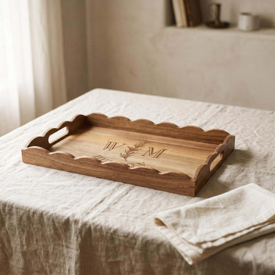 Scalloped acacia wood tray styled in a softly lit dining room