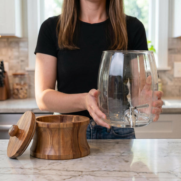 Woman assembling the clear glass drink dispenser