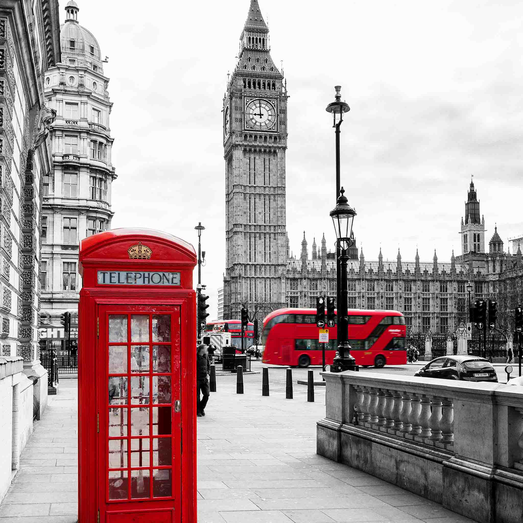 Red London telephone box and double decker buses with view of Big Ben