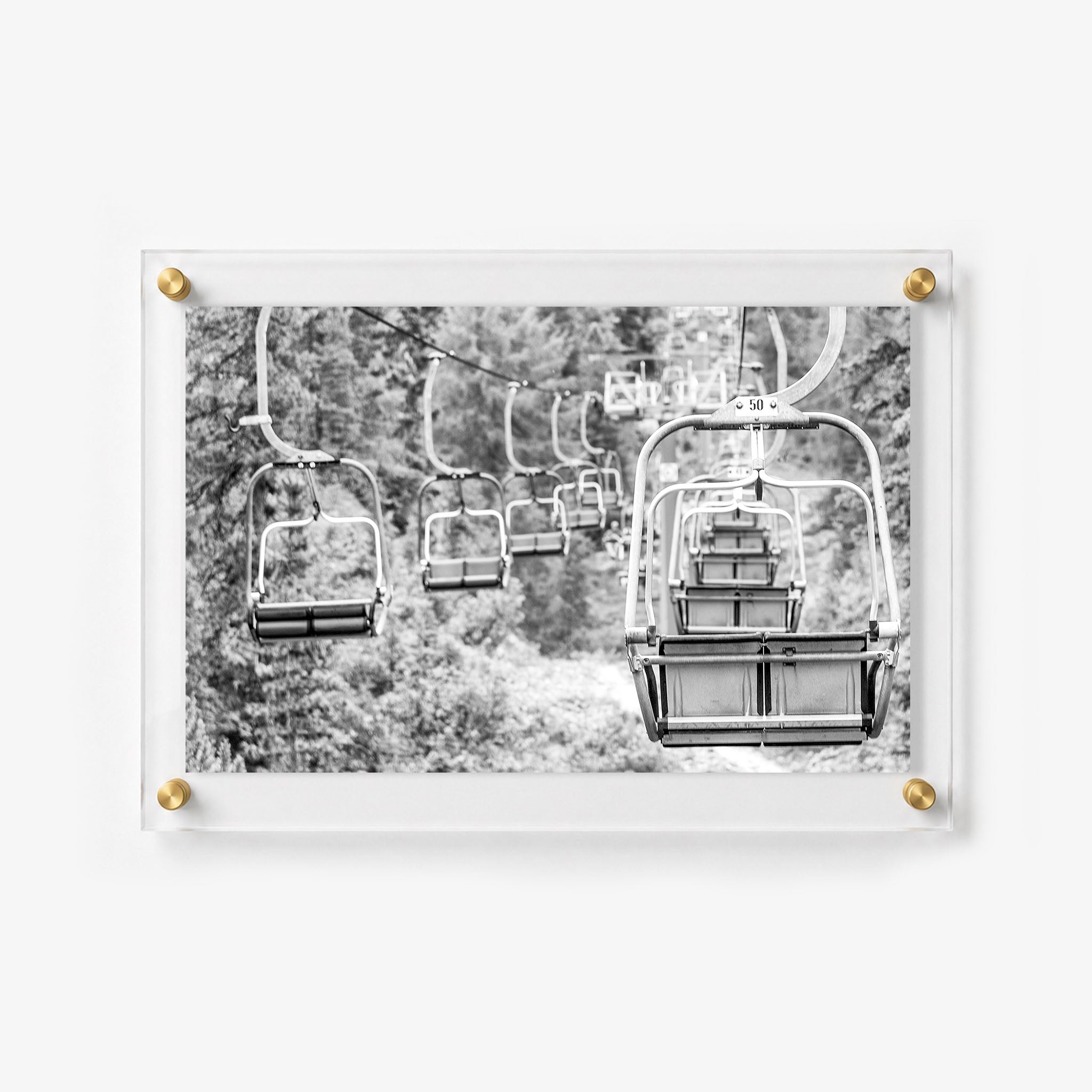 Scenic ski lift chairs suspended over a mountain trail