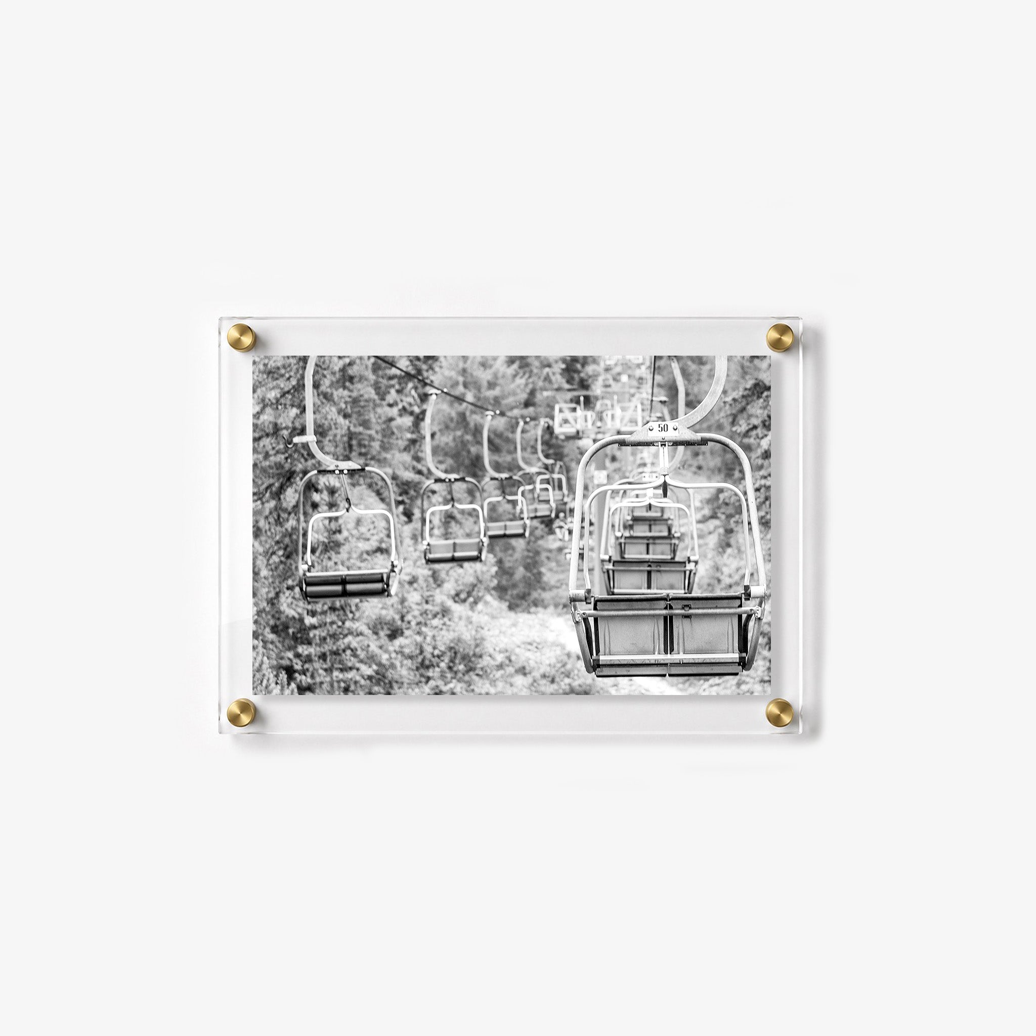 Empty chairlift line above a wooded hillside