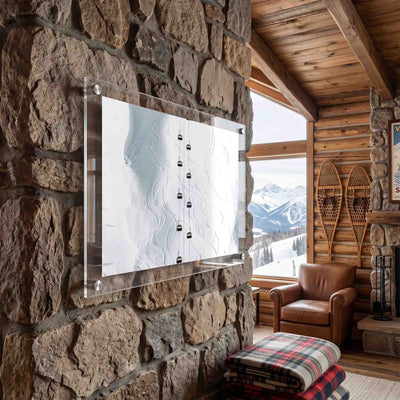 Snowy mountain wall art with ski lift cabins displayed at a cabin