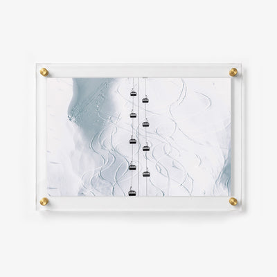 Acrylic wall art of gondolas suspended above a bright white ski slope