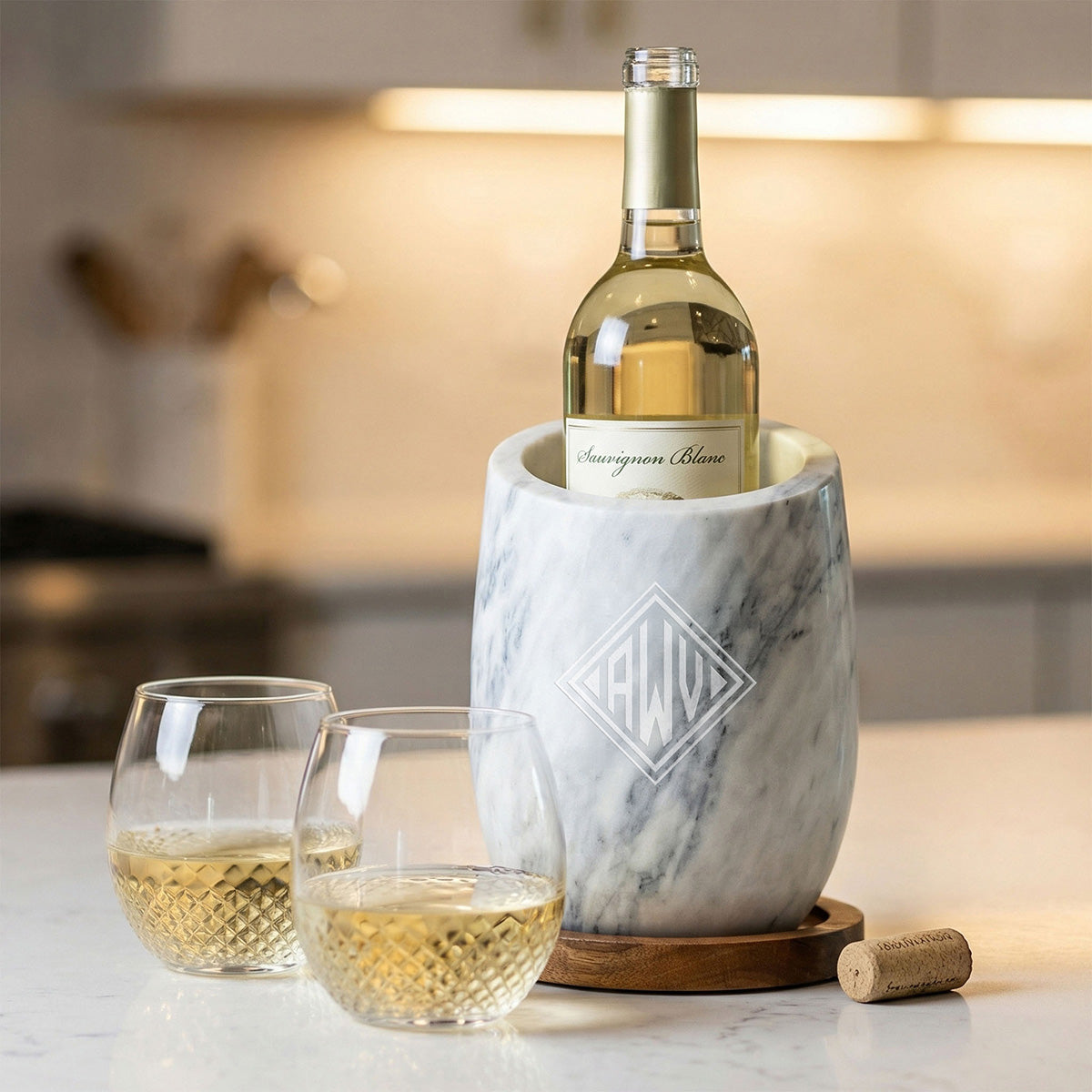 Two avignon glasses with white wine next to a marble wine chiller