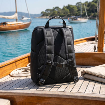 Backpack cooler with padded straps sitting on a boat deck