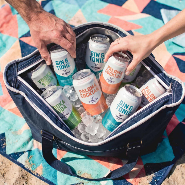 Navy insulated tote bag filled with canned cocktails and ice