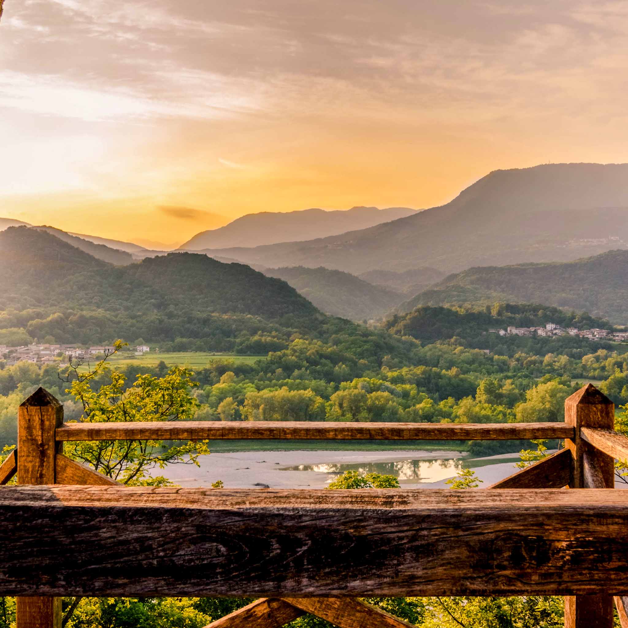 Peaceful valley and distant mountains under a glowing sky