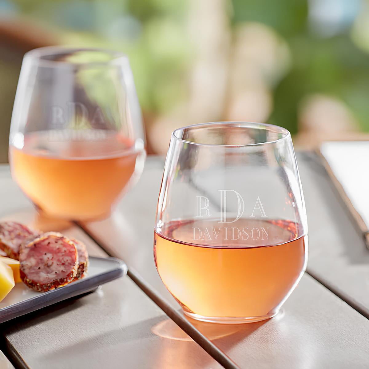 Close-up of the stemless wine glass with engraved initials and name.