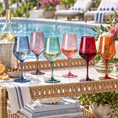 six colorful wine glasses displayed beside swimming pool
