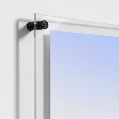 Close up of black mounting hardware securing a clear acrylic wall art panel