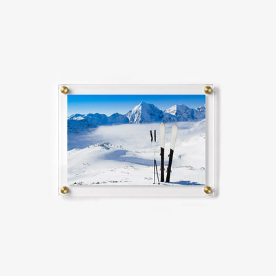 Winter mountain wall print showing skis and poles above a bright snow filled valley