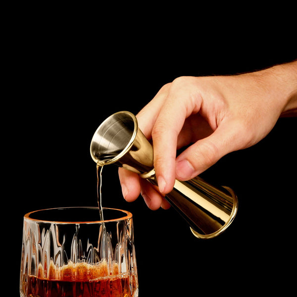 Liquor poured into the rocks glass using the Langford Gold Jigger Bar Tool.