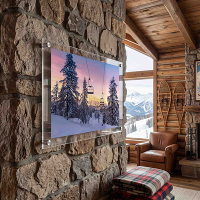 Acrylic wall art featuring chairlifts over a snowy mountain forest displayed in a cabin