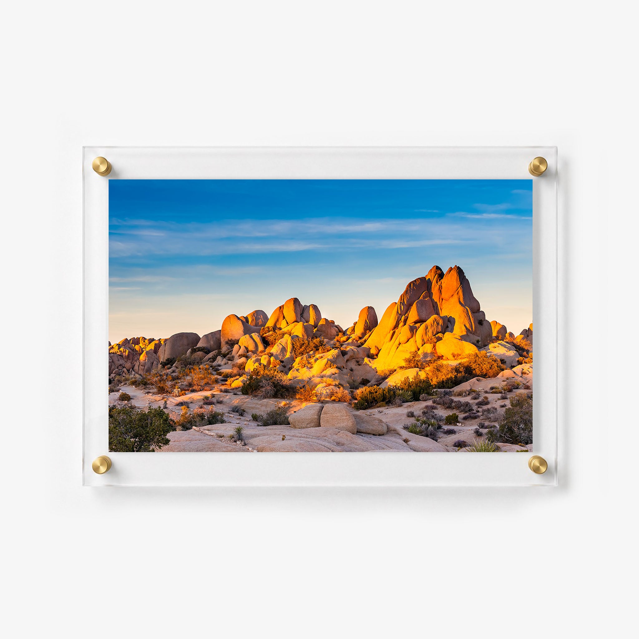 Acrylic wall art of rocky desert terrain surrounded by low shrubs and open sky