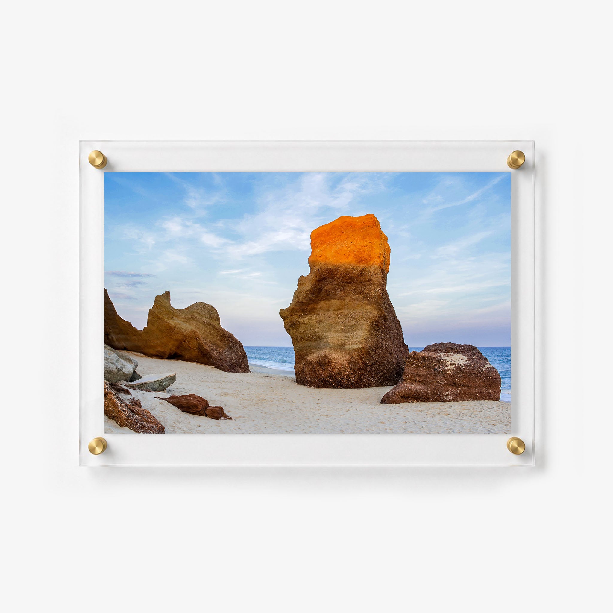 Horizontal acrylic print featuring dramatic coastal rocks lit by warm sunlight