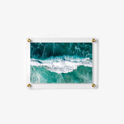 Overhead view of a breaking wave surrounded by swirling white sea foam
