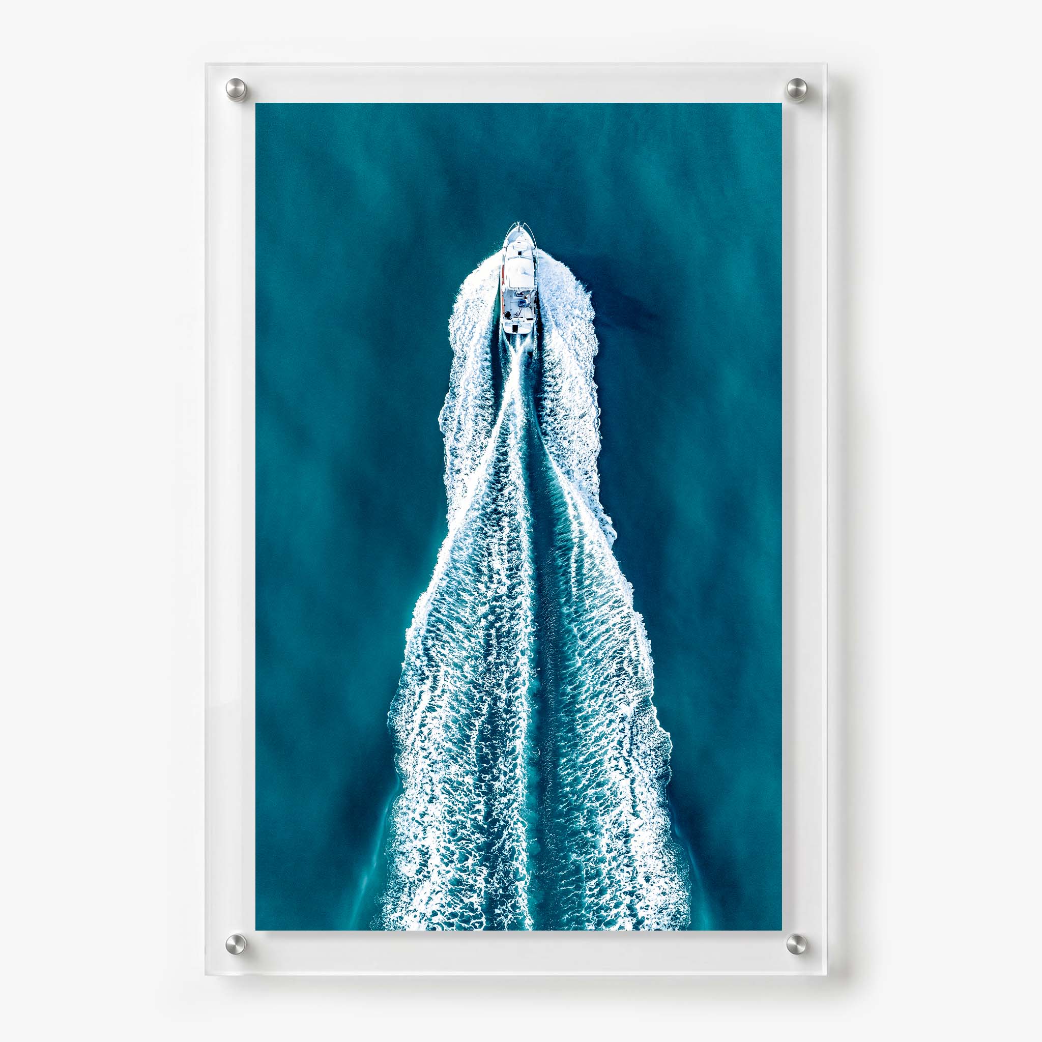 Acrylic wall art featuring an aerial view of a motorboat speeding across deep blue water