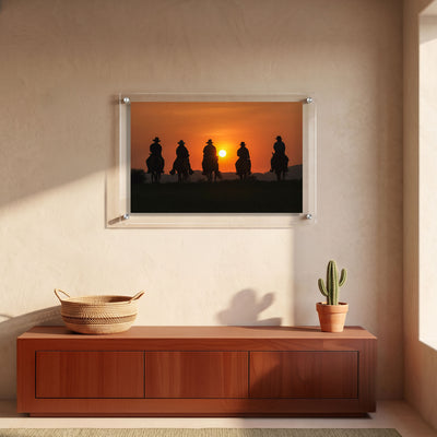 Acrylic print of cowboys riding horses toward the setting sun displayed in an entryway