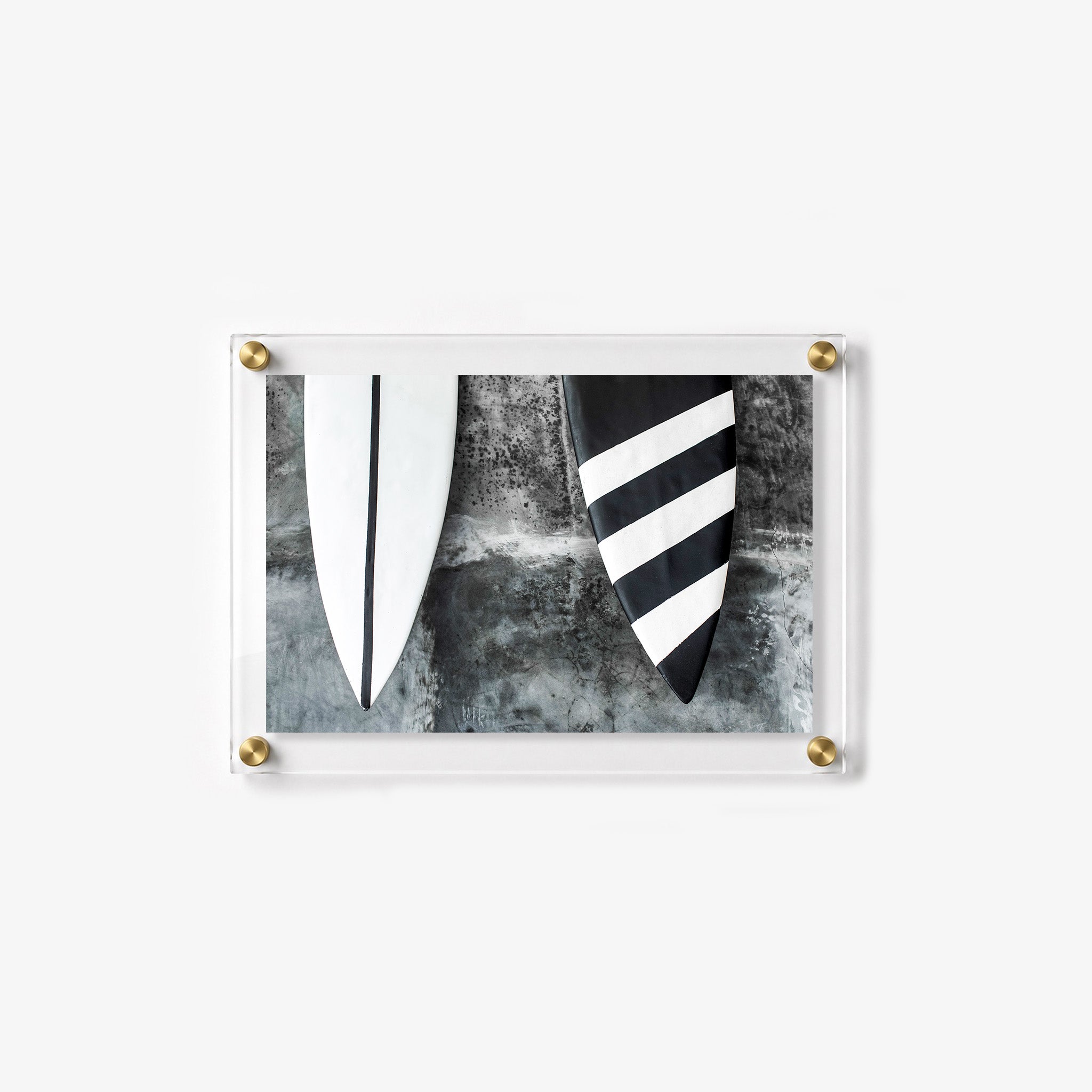 Close up wall art showing the pointed ends of two surfboards with contrasting striped patterns