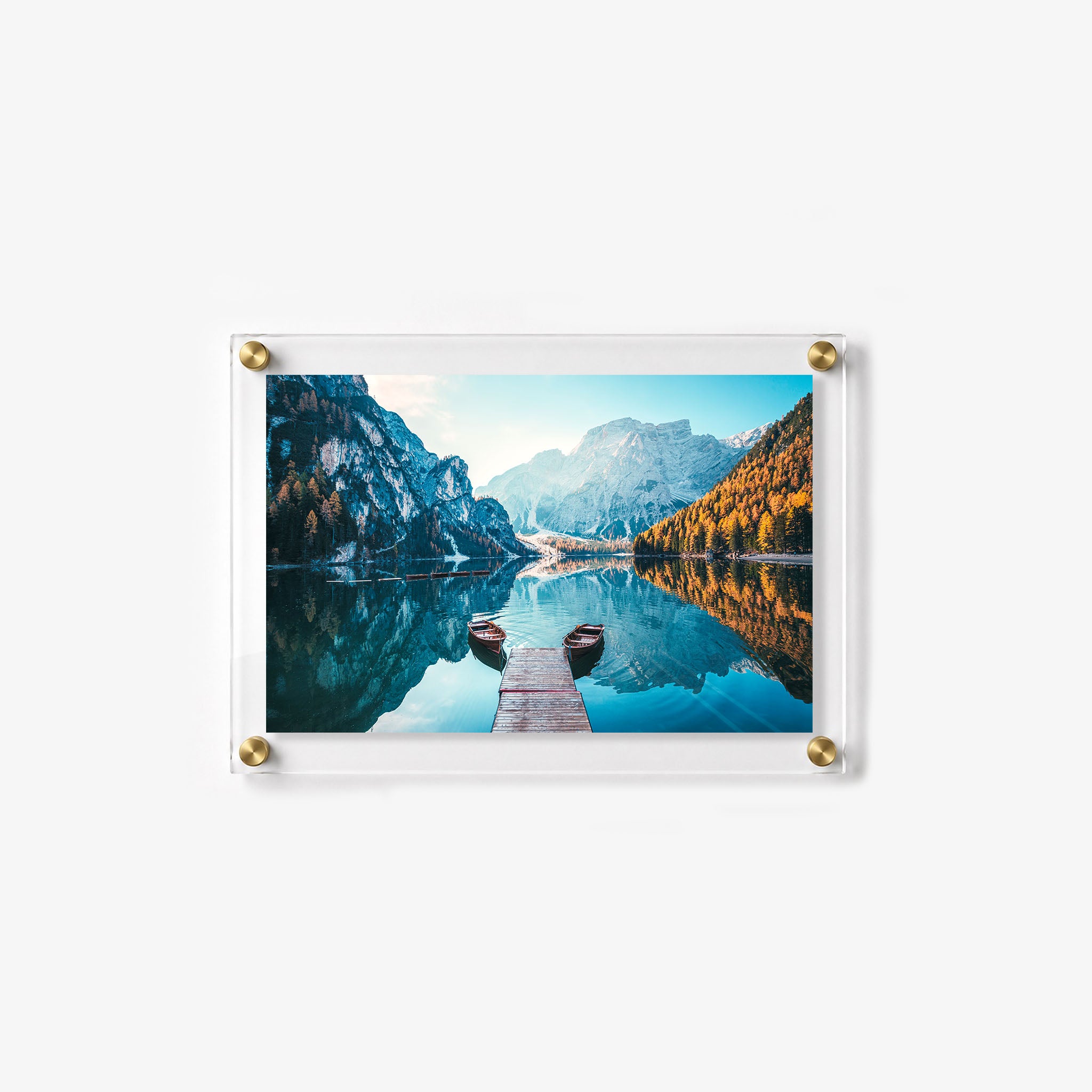 Peaceful alpine landscape with a dock, two wooden boats, and dramatic mountain reflections