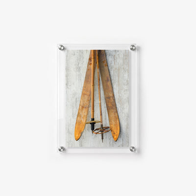 Antique skis and bamboo poles displayed against a distressed wood backdrop