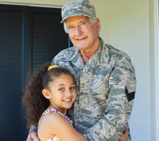 Military grandfather embracing his granddaughter
