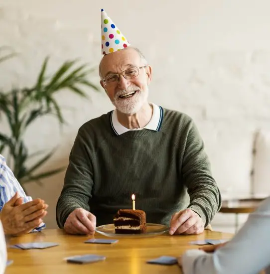 70 year old man celebrating birthday with cake