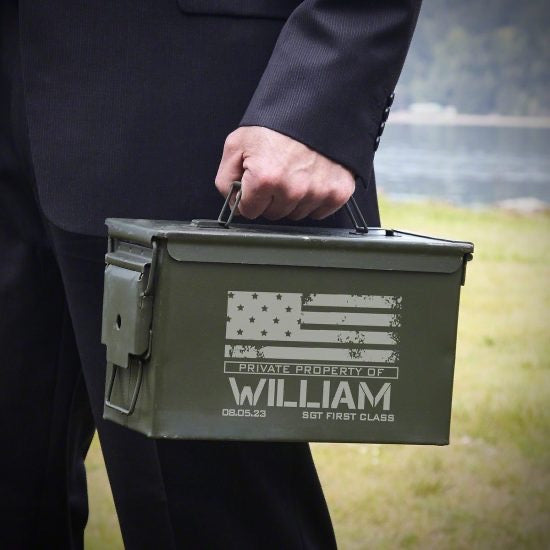 Man in suit holding ammo can gift for military retirees