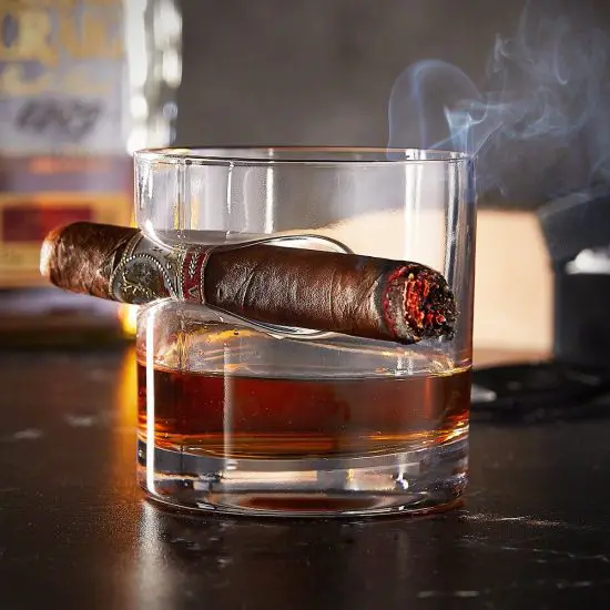 Round cigar glass with lit cigar attached