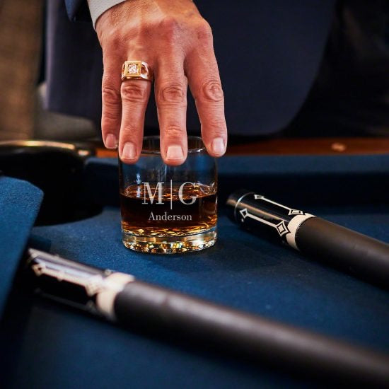 Man grasping glass on pool table