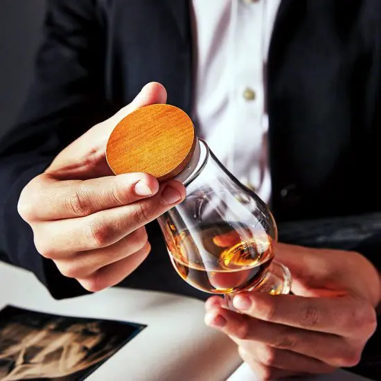 man putting topper on bourbon glass