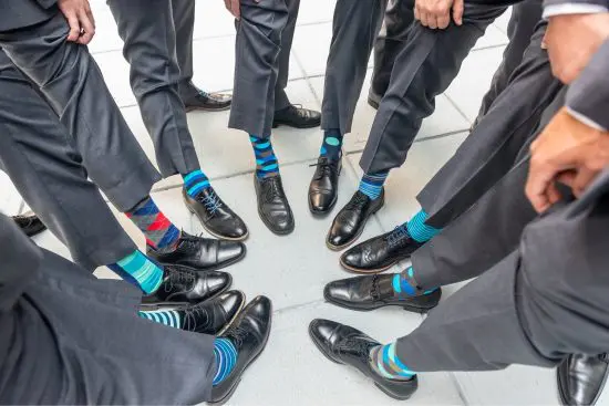 groomsmen standing in circle showing their socks