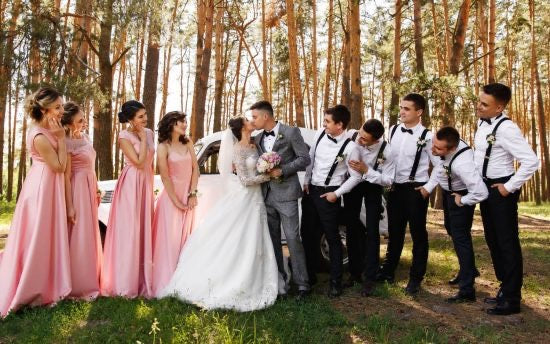 Wedding party watching bride and groom kiss