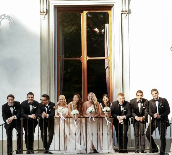 groomsmen and wedding party posing on a balcony