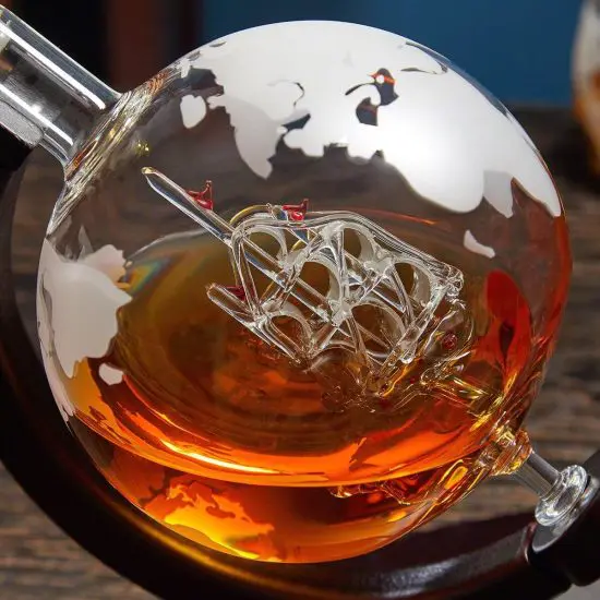 Close up of globe bourbon decanter on wood stand