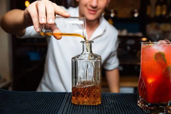 Man pouring bourbon into a decanter