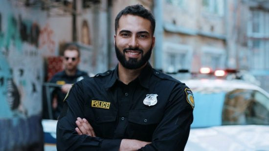 Law enforcement officer in front of squad car