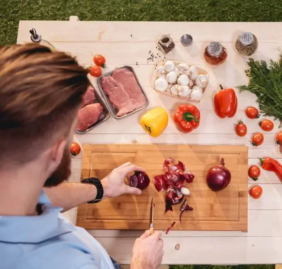 Man cutting food on a charcuterie board