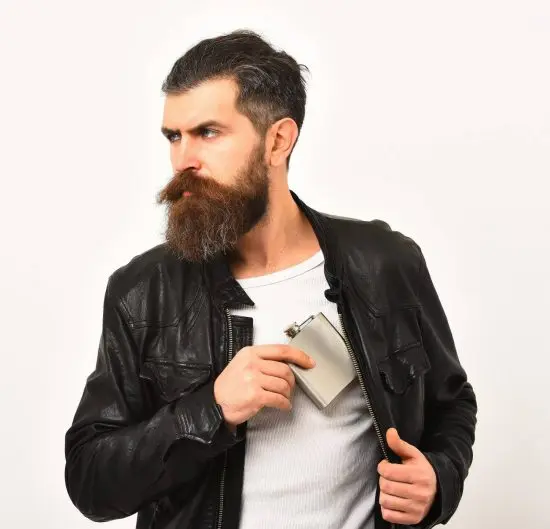 Man pulling flask from his leather jacket