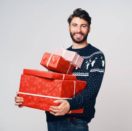 Man holding several boxes of gifts for men
