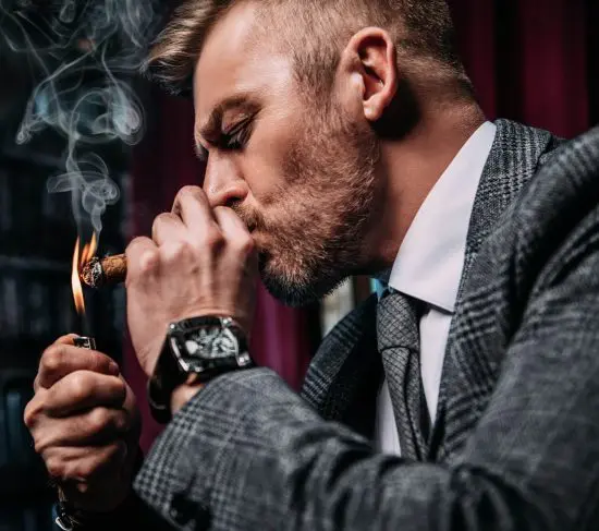 Man in suit lighting a cigar