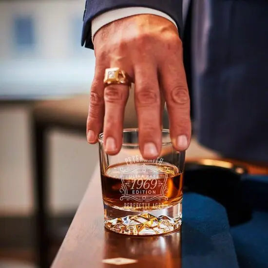Man with ring grabbing bourbon glass