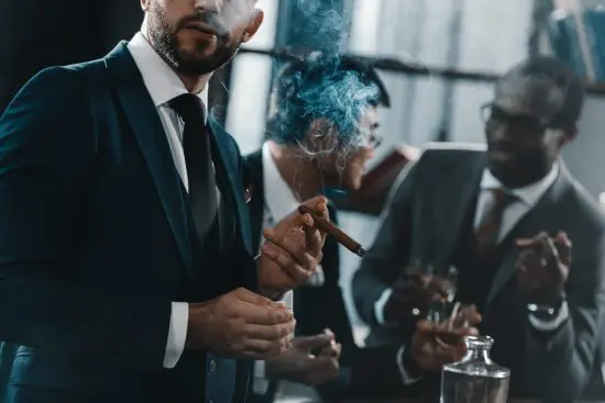 Three men smoking cigars and drinking whiskey