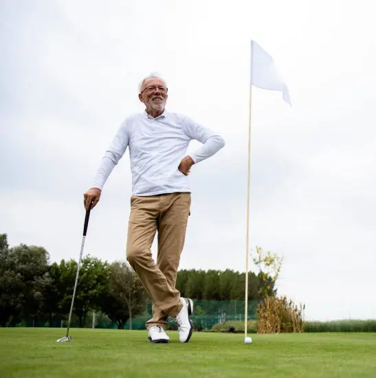 Retired man posing at golf hole
