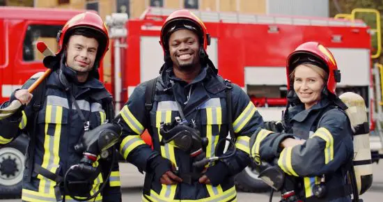 Three firefighters standing in front of a fire truck